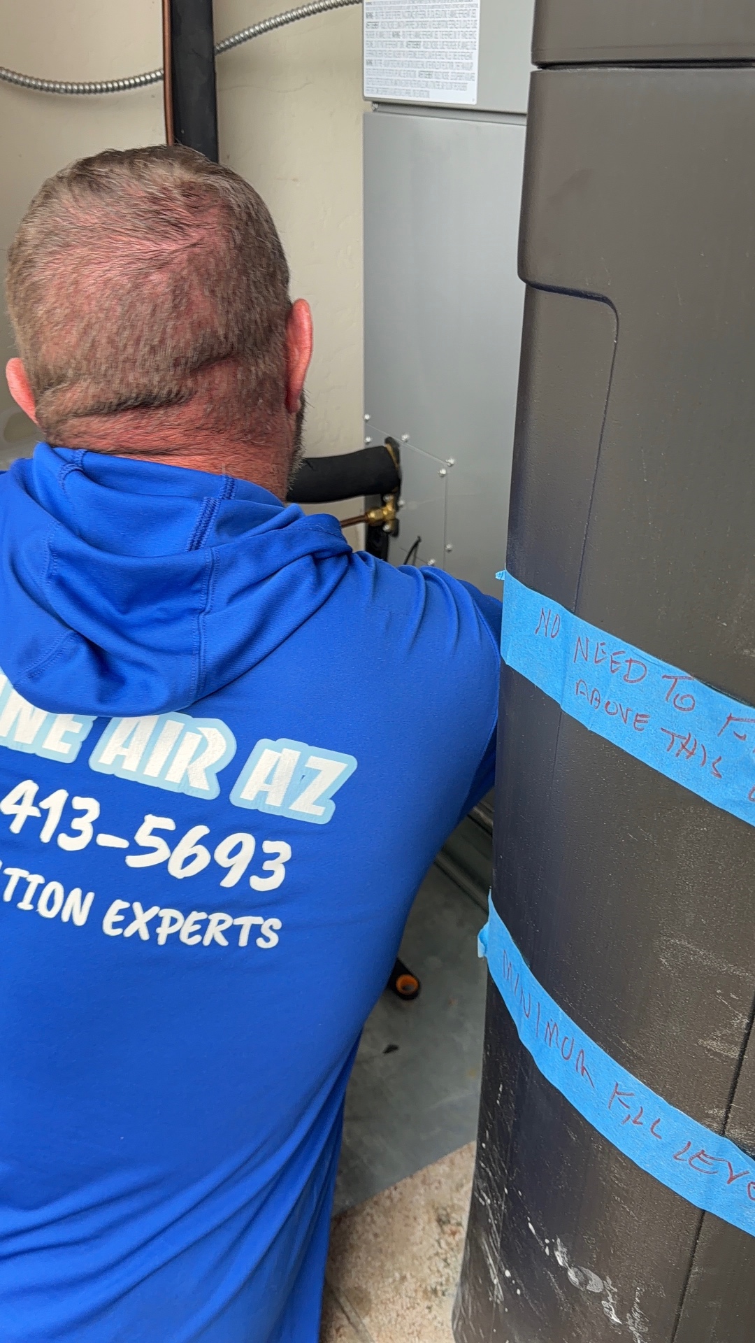 Insane Air technician performing preventative HVAC maintenance on an air handler